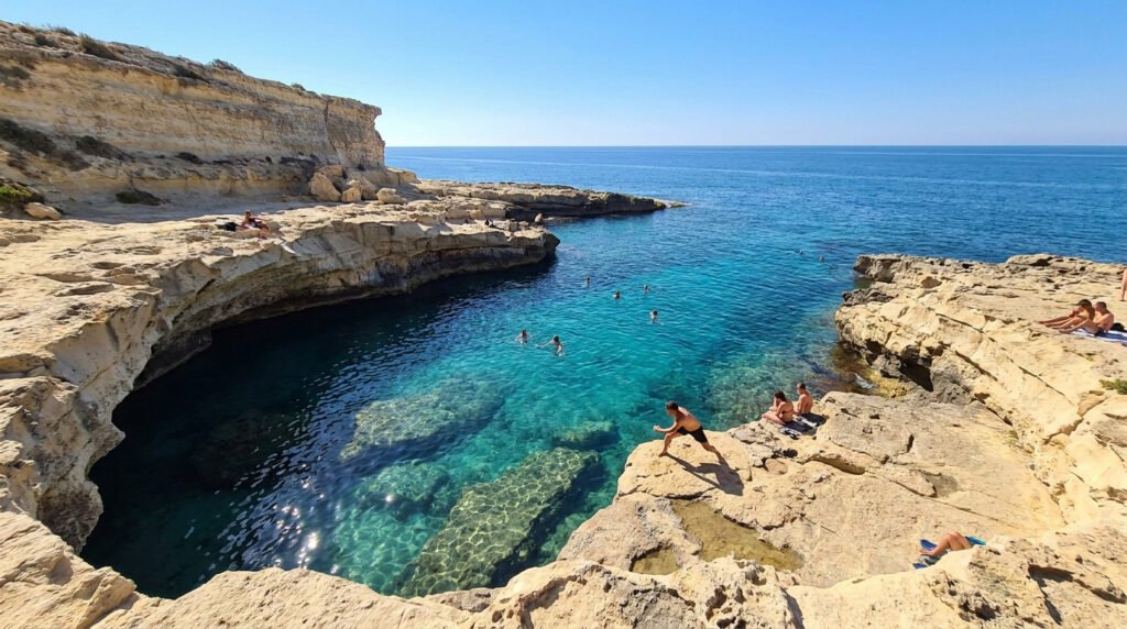 Swimmers in the crystal-clear turquoise waters of St. Peter's Pool surrounded by dramatic limestone rock formations.
